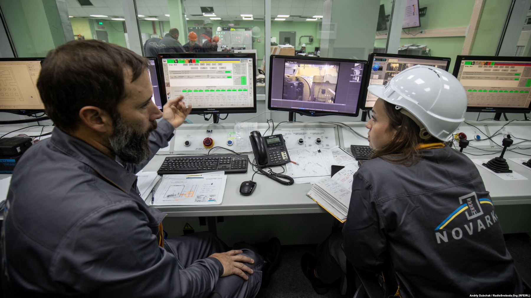 Two nuclear containment specialists inside the main control center at the New Safe Confinement (NSC). Some 3,000 people work at the site, including several foreign specialists. Photo by: Andriy Dubchak