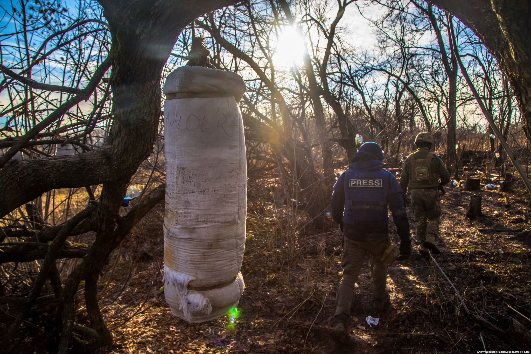 Hand-made punch bag in a wood lane. Near that improvised sports ground between trees, there are many mine craters. We also saw the remnants of an unexploded rocket-propelled grenade.) (photo by ukrainian military photographer Andriy Dubchak)