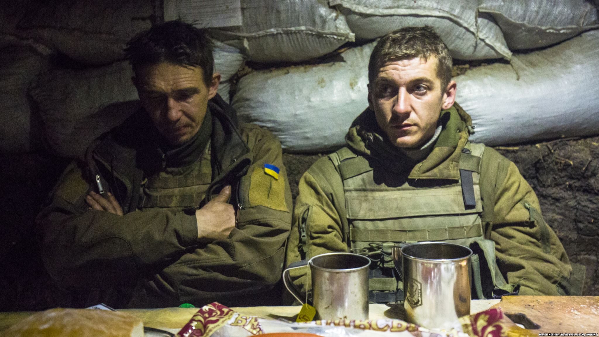 Dinner in the middle of fighting. Men drink tea and rest in a kitchen-dugout, while other soldiers were suppressing enemy fire