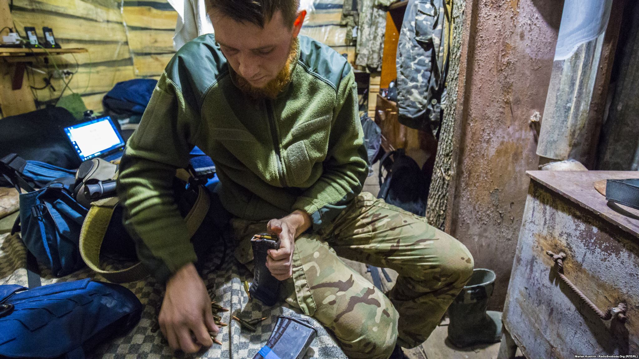 Yevhen loads rounds to assault rifle’s magazine before going to the frontline with us