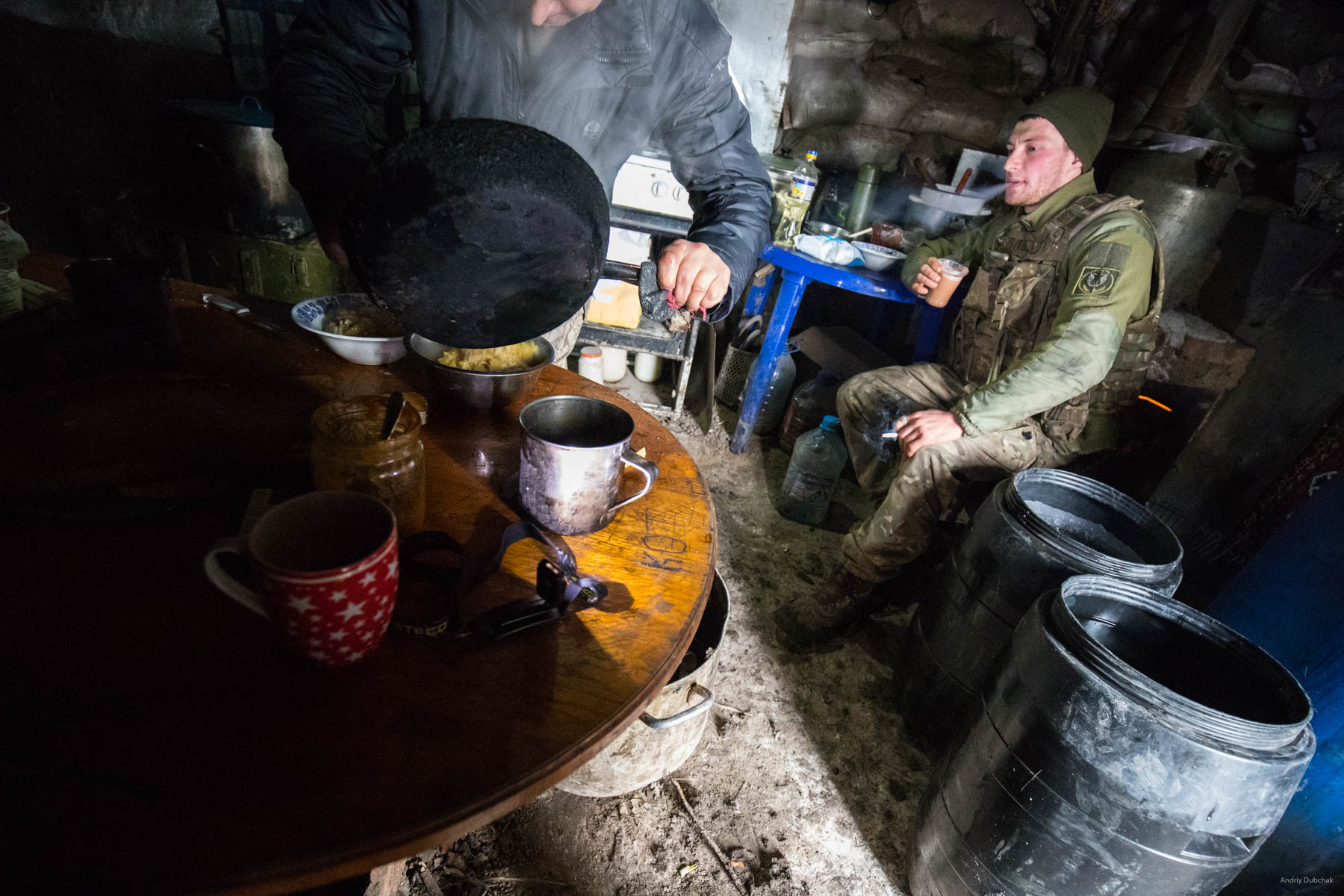A marine drinks coffee and smokes in a kitchen-dugout, near Shirokine. Local "club" - a kitchen, some people are always there, the place you can eat at(they cook all the time), drink coffee with a cigar (almost everyone smokes), talk. Usually there is good Wi-Fi. Shirokine, March 2018.