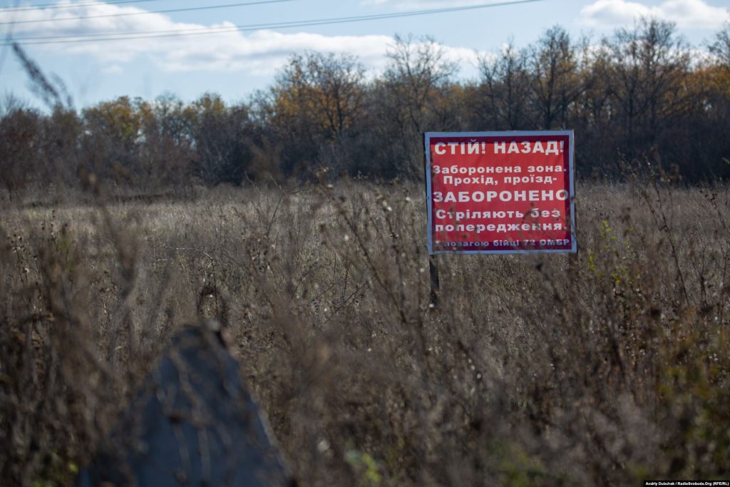 We walk from Zolote-4 to Katerynivka; part of the road is in the “grey zone”. To the left of the road are signs, politely warning passers-by that they might be shot at without warning (Ukraine reporter Andriy Dubchak)