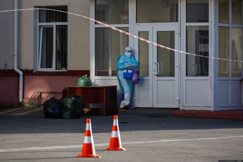 A medical worker collects supplies dropped off at Kalynivka’s hospital. The facility is now effectively sealed off from the outside world. Waste is picked up and supplies are dropped off by people who avoid direct contact with the staff inside. Photographer Andriy Dubchak / Ukraine