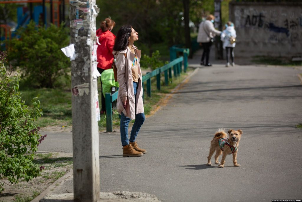 Дівчина, яка вигулює песика, підставляє обличчя весняному сонцю. Фото - Андрій Дубчак