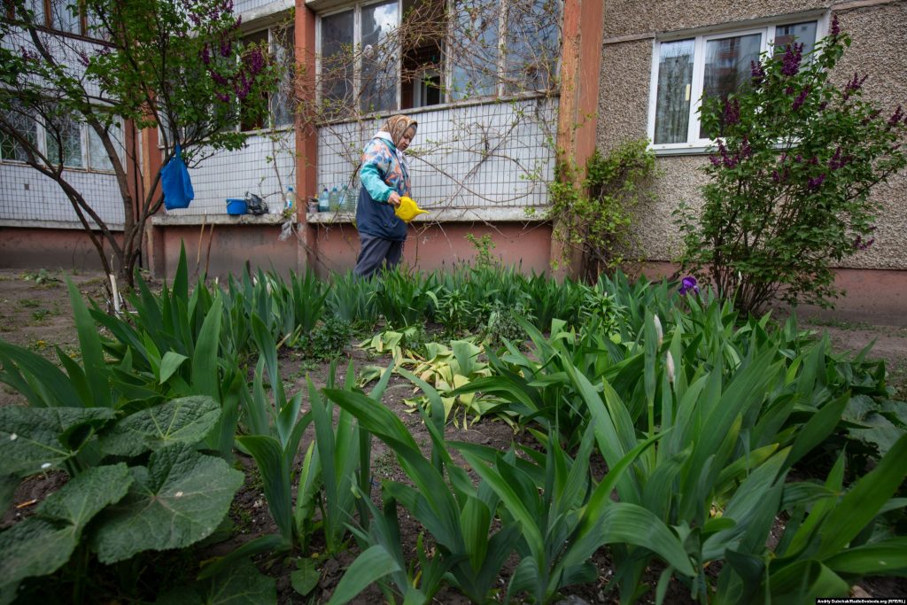 79-річна Марія Іванівна поливає квіти під своїм балконом. Фото - Андрій Дубчак